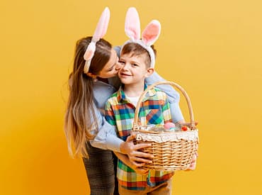 Mãe e filho com tiara de orelhas de coelho da páscoa, ambos segurando uma cesta de presente de páscoa