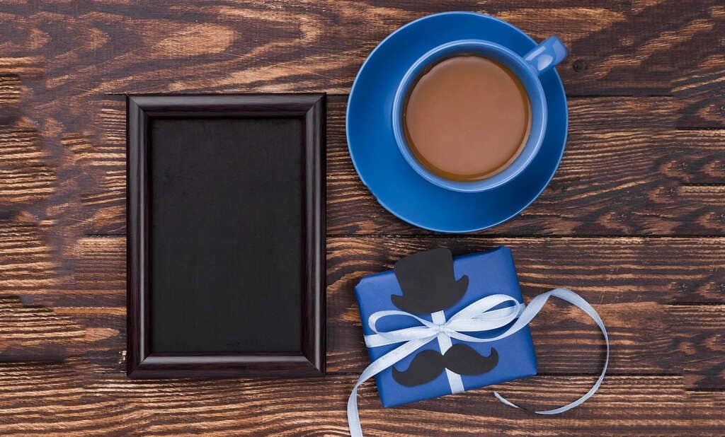 Caneca, simbolizando brinde. Porta retrato vazio, simbolizando personalizado. Embalagem de presentes (caixinha com fita) azul, simbolizando dia dos pais.